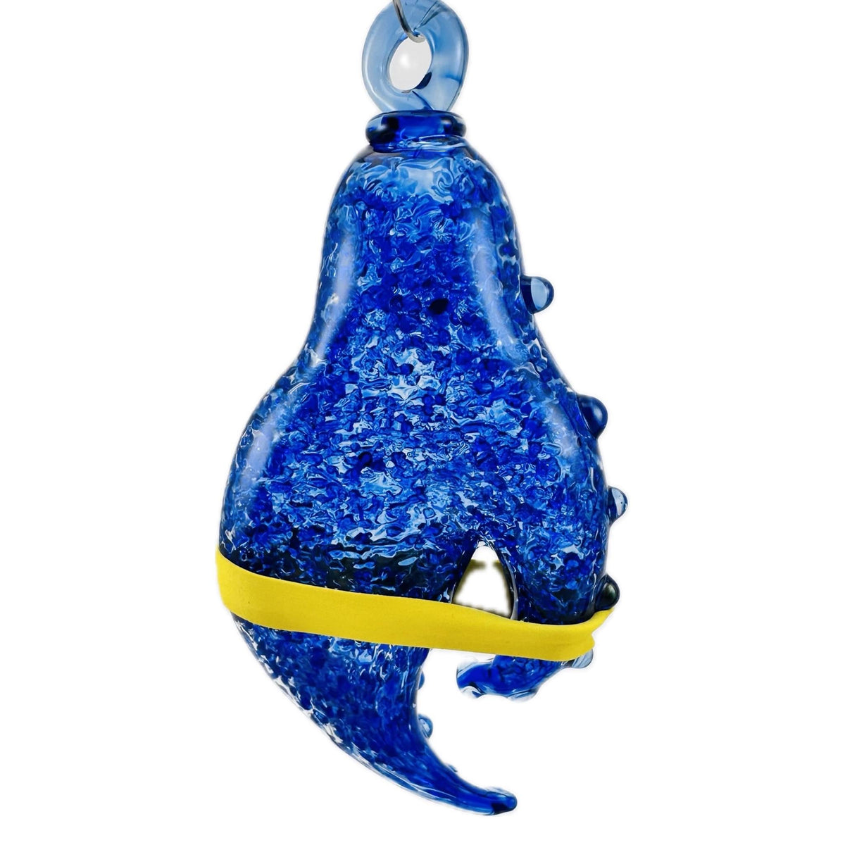 A blue textured glass shark ornament with a yellow band around its midsection, shown against a plain white background.
