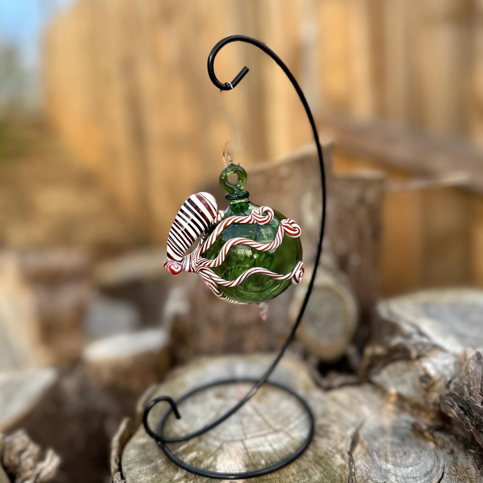 Decorative glass ornament on a stand with a blurred natural background
