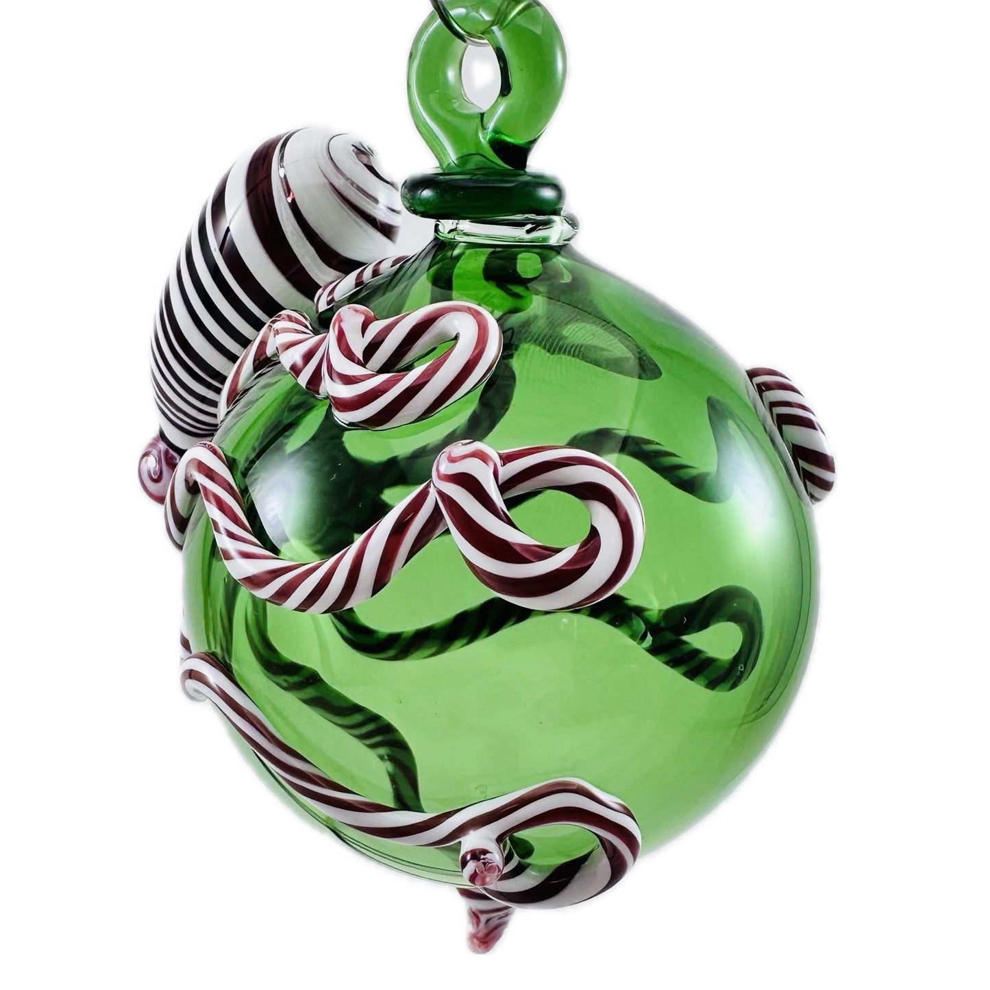 Green glass ornament with candy cane design on a white background