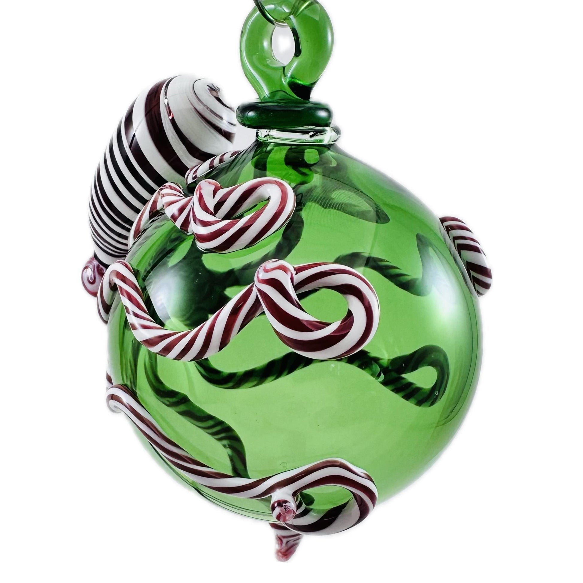 Green glass ornament with candy cane design on a white background
